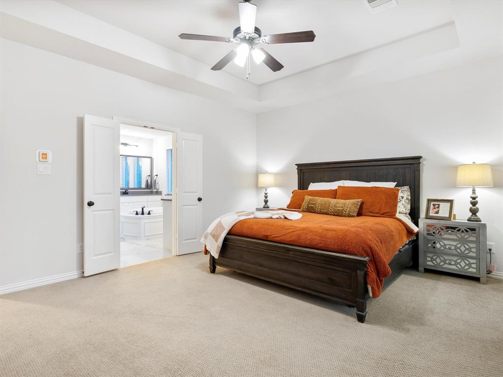 2156 Cloverfern Way Haslet, TX 76052 - Photo 21 of 40 a spacious bedroom with a bed and cabinets