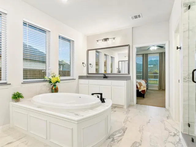 a spacious bathroom with a bathtub shower sink and mirror