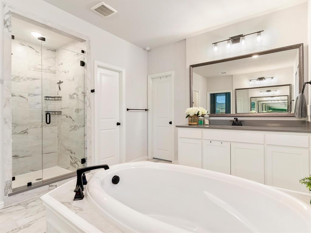 2156 Cloverfern Way Haslet, TX 76052 - Photo 25 of 40 a spacious bathroom with a bathtub shower sink and mirror