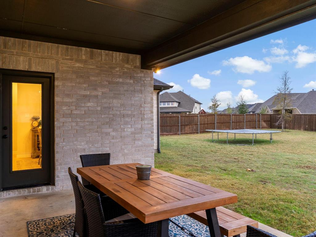 2156 Cloverfern Way Haslet, TX 76052 - Photo 35 of 40 a backyard of a house with wooden floor table and chairs
