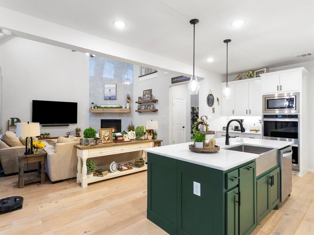 2156 Cloverfern Way Haslet, TX 76052 - Photo 10 of 40 a kitchen with kitchen island granite countertop a sink cabinets and stainless steel appliances