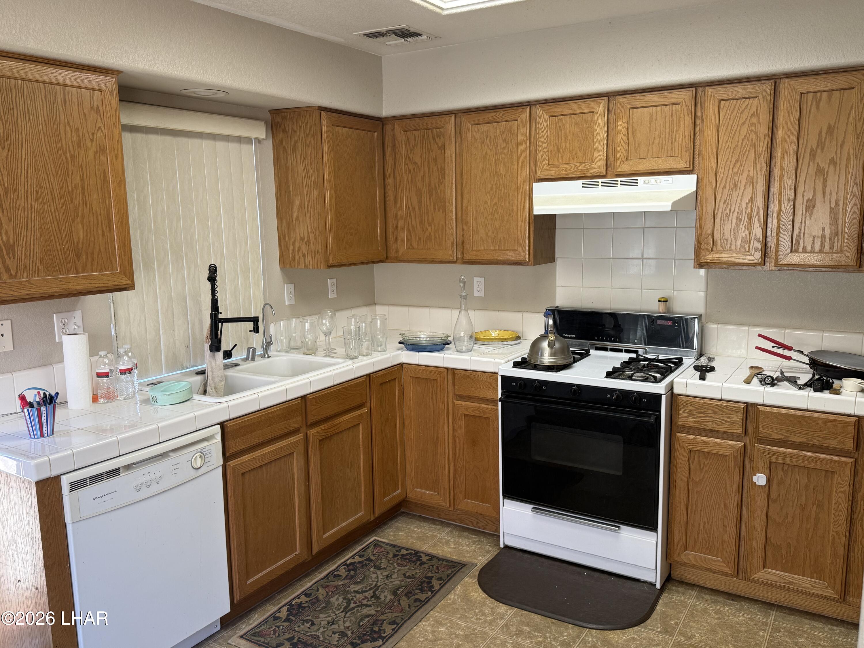 4897 South Rinaldi Drive Fort Mohave, AZ 86426 - Photo 7 of 22 a kitchen with a sink stove and cabinets