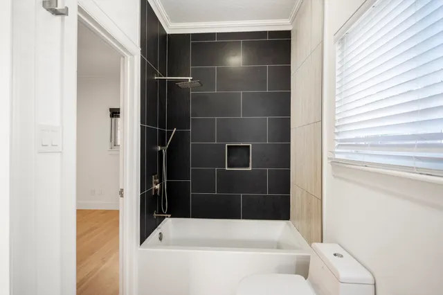 an empty room with wooden floor ceiling fan and windows