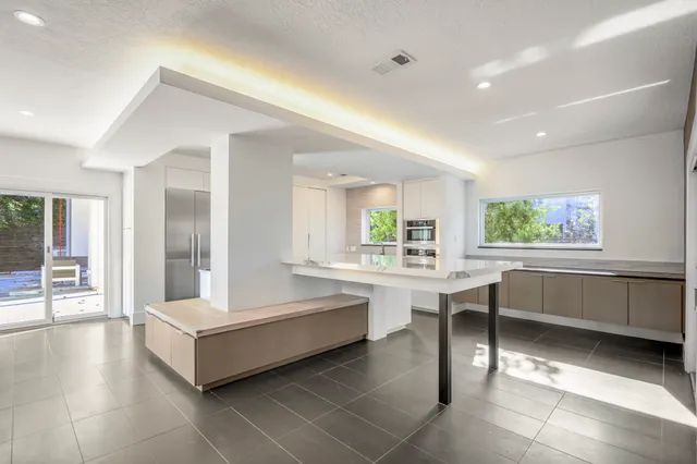 a large white kitchen with a large window