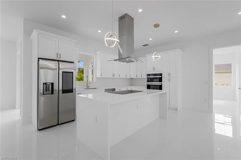9107 Henry Road Fort Myers, FL 33967 - Photo 8 of 26 a kitchen with stainless steel appliances kitchen island a refrigerator and a stove