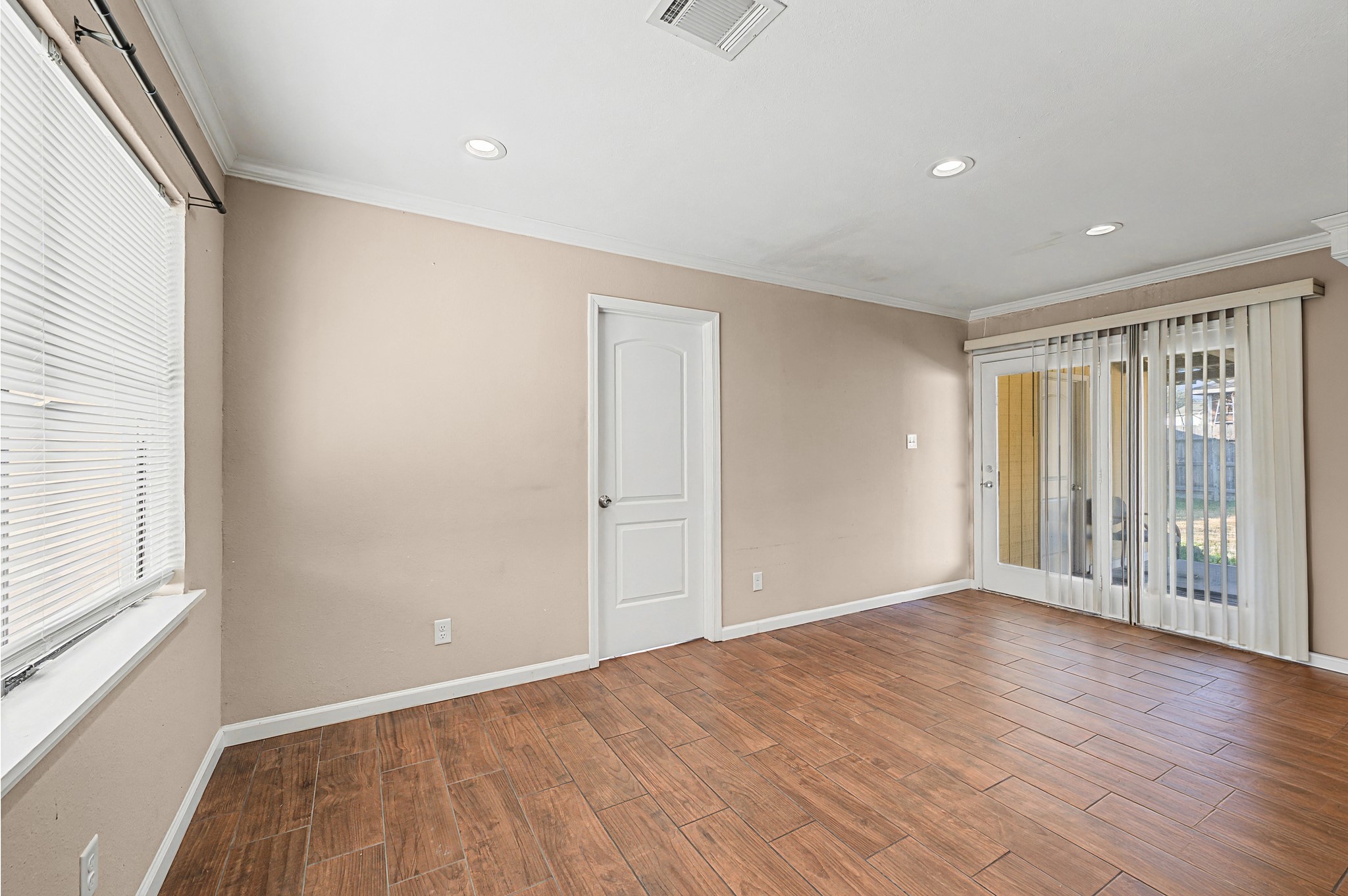 823 Marleen Street Houston, TX 77034 - Photo 5 of 15 a view of an empty room with wooden floor and a window