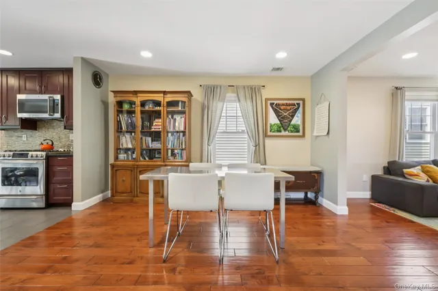a dining room with furniture a window and wooden floor