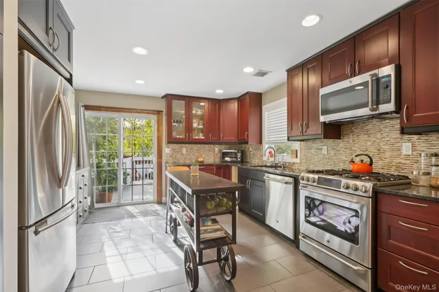 a kitchen with stainless steel appliances granite countertop a refrigerator stove microwave and sink