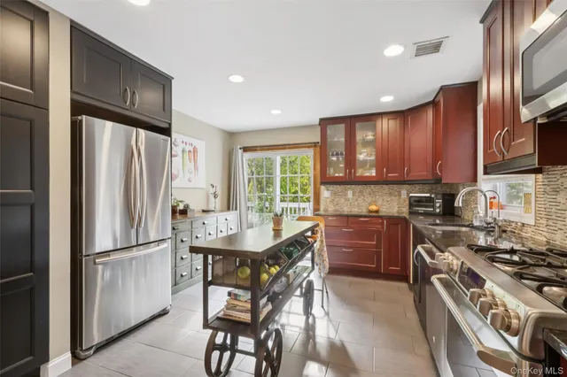 a kitchen with stainless steel appliances granite countertop a refrigerator stove microwave and sink