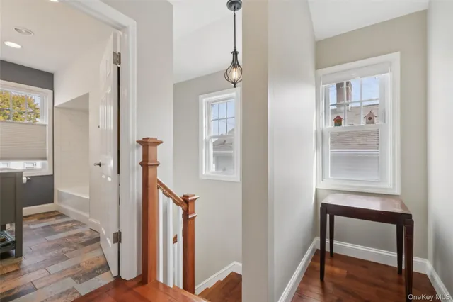 a view of a hallway with wooden floor and a living room