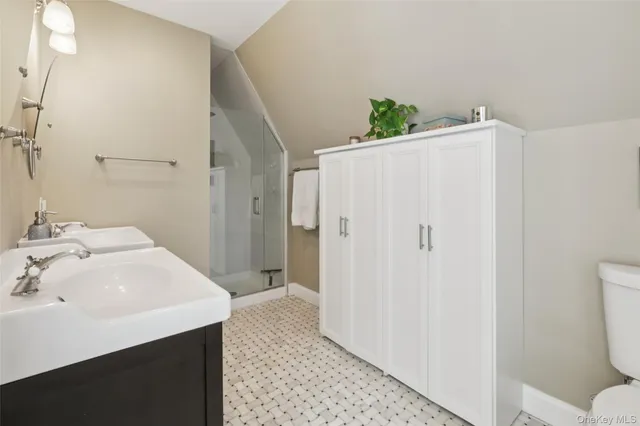 a bathroom with a sink a toilet and shower