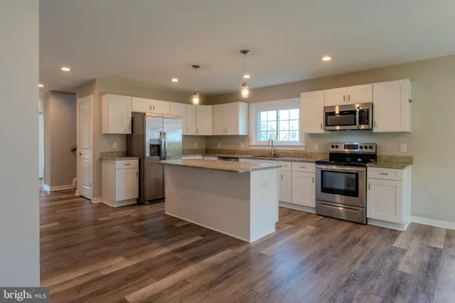 a bathroom with a granite countertop toilet and sink