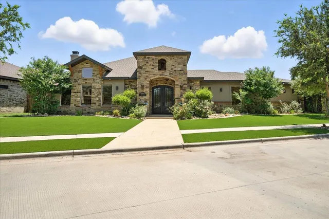 a view of a house with a big yard and large trees