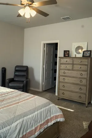 a bedroom with a bed and a ceiling fan