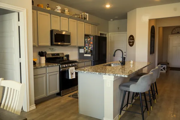 a kitchen with stainless steel appliances kitchen island a refrigerator and a stove top oven