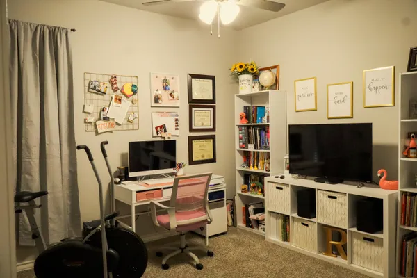 a view of a livingroom with workspace and a window