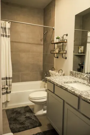 a bathroom with a granite countertop sink toilet and shower