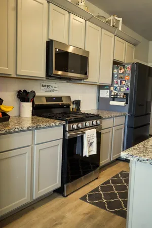 a kitchen with stainless steel appliances granite countertop a stove a sink and a microwave