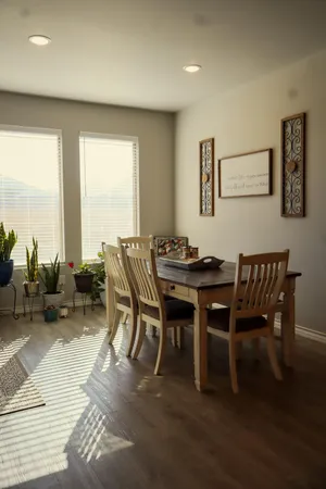 a dining room with furniture and a floor to ceiling window