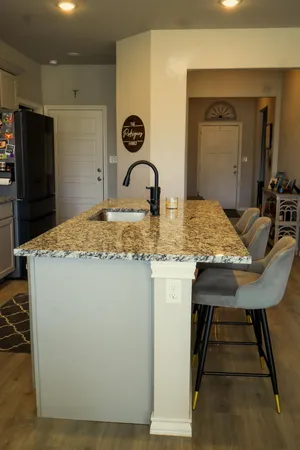 a room with a table chairs and refrigerator