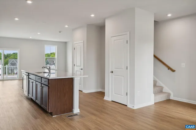 a view of a hallway with wooden floor and staircase