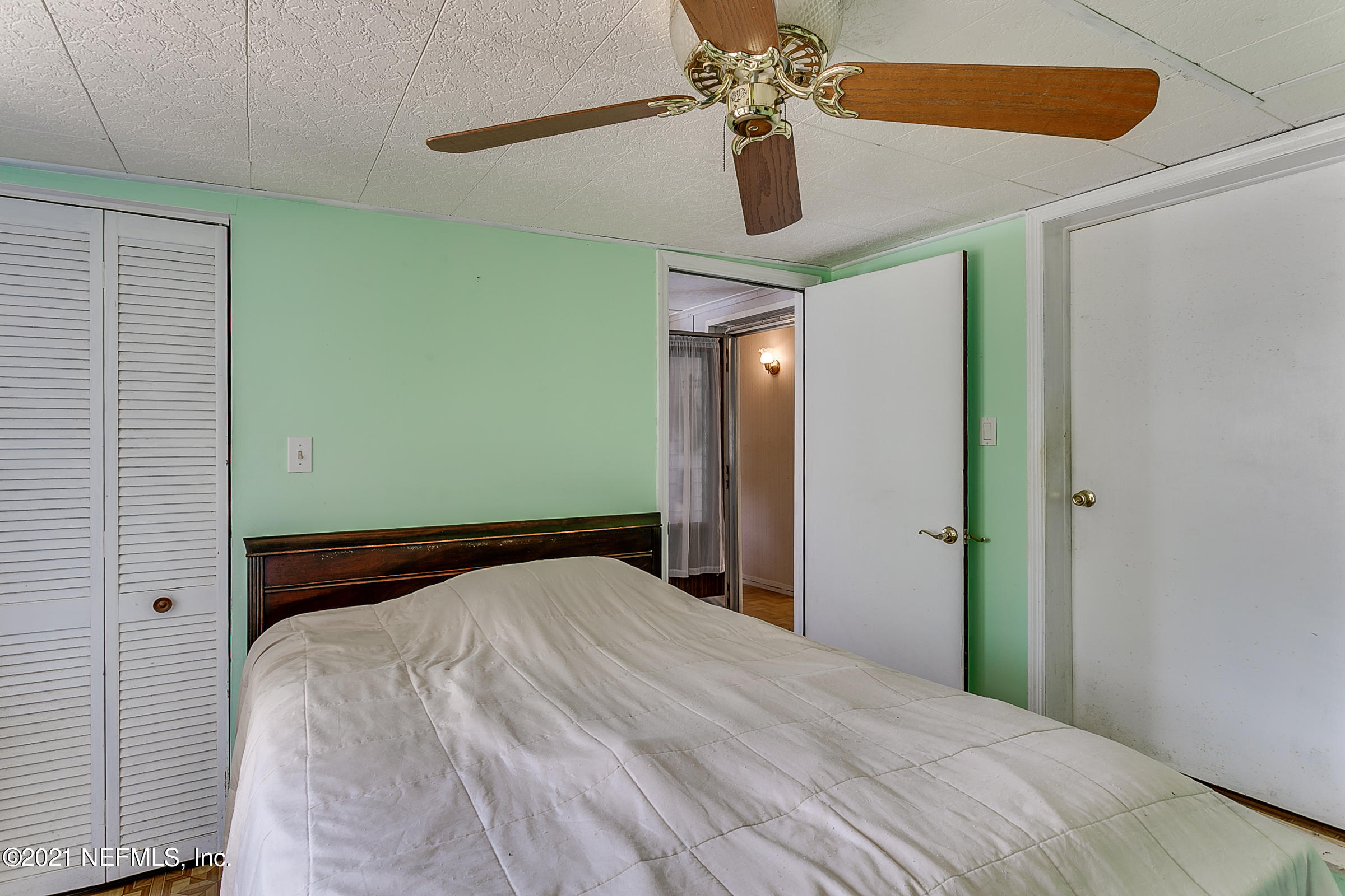 7004 Deer Springs Road Keystone Heights, FL 32656 - Photo 21 of 25 a bedroom with a bed and a chandelier