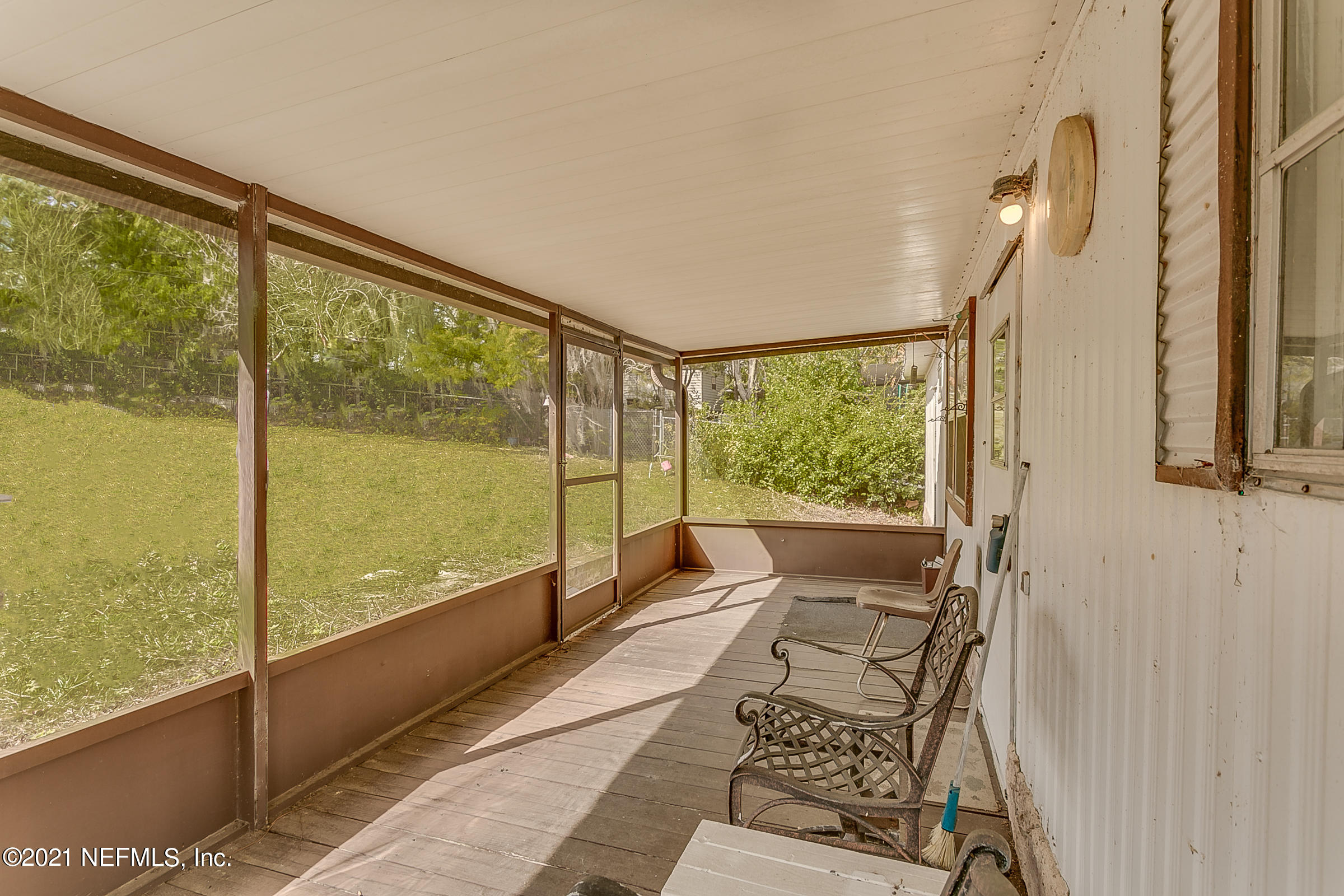 7004 Deer Springs Road Keystone Heights, FL 32656 - Photo 9 of 25 a living room with large windows and a table