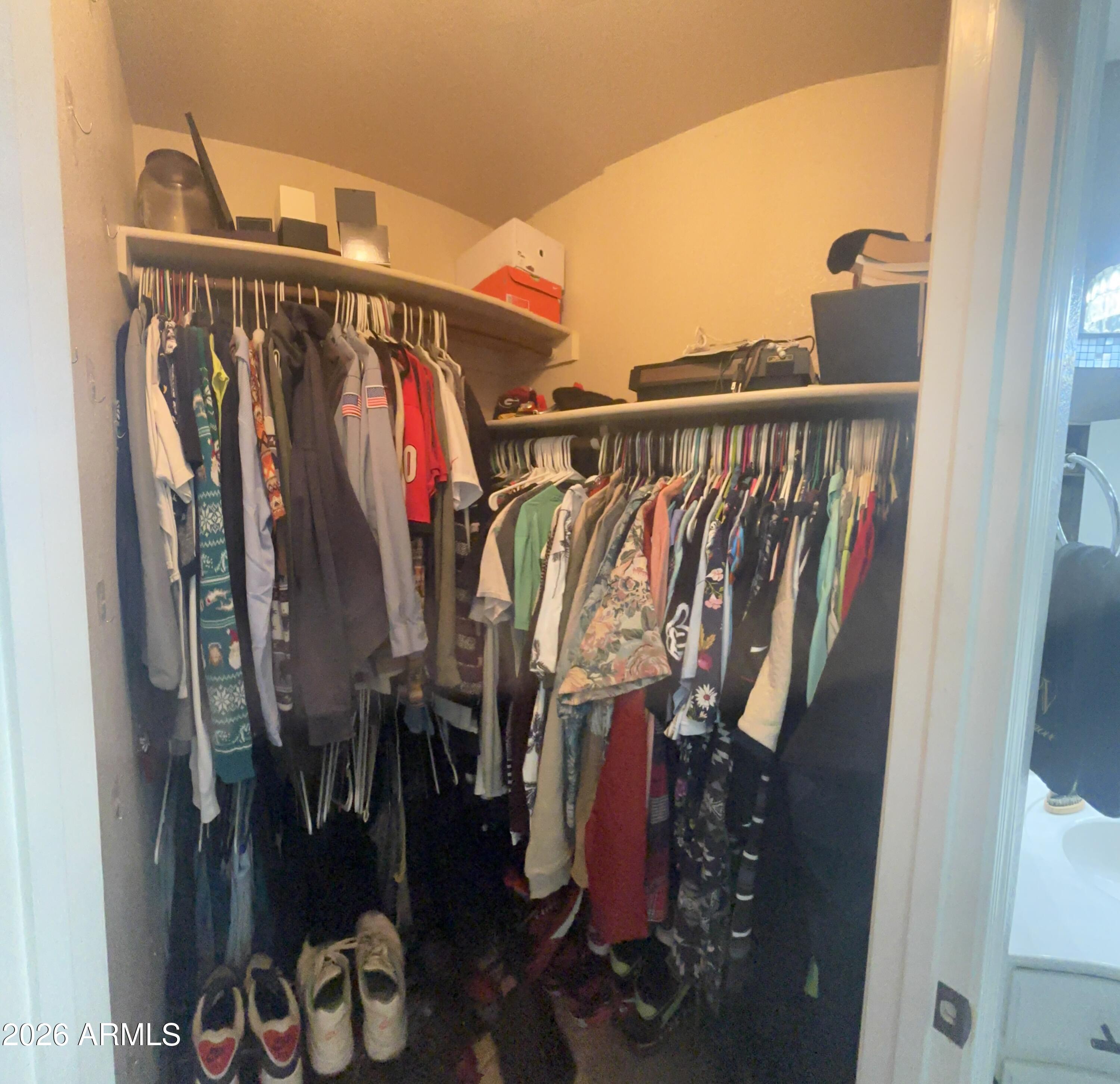 9002 West Coronado Road Phoenix, AZ 85037 - Photo 31 of 48 a view of walk in closet with clothes and shoes