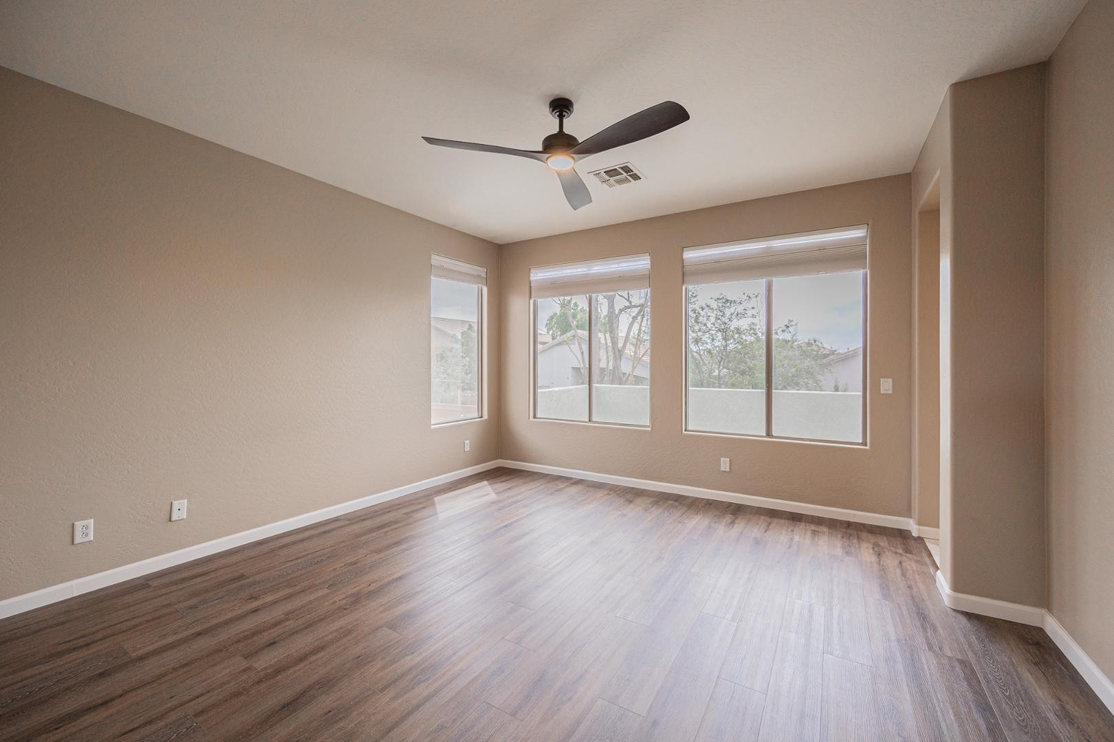 6539 West Jomax Road Phoenix, AZ 85083 - Photo 15 of 39 a view of an empty room with wooden floor and a window