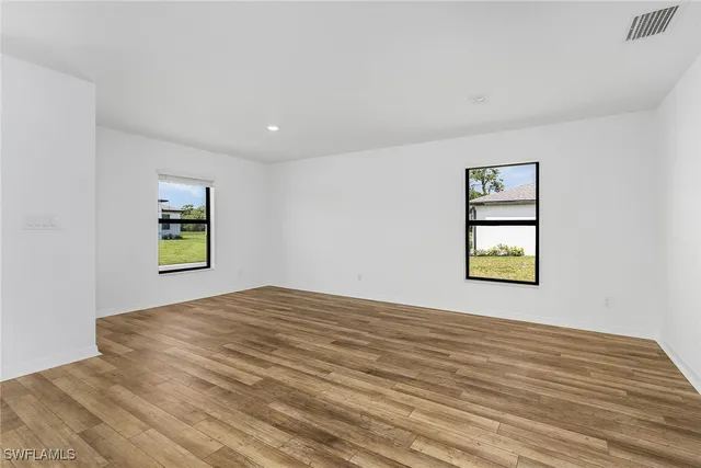 a view of a bedroom with wooden floor and a window