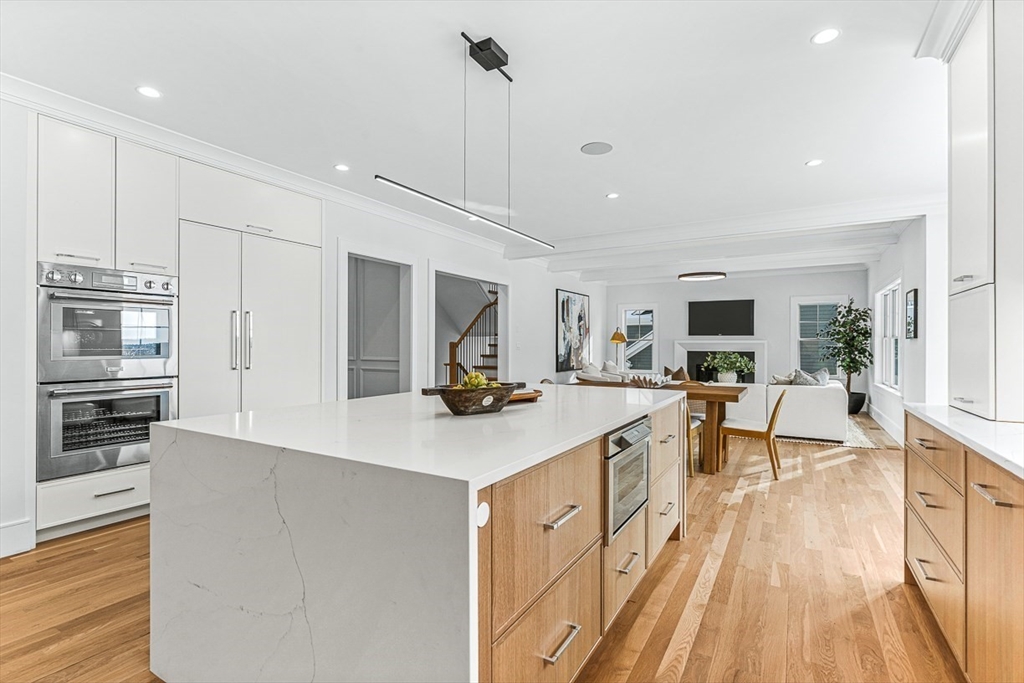 123 Lawton Road Needham, MA 02492 - Photo 2 of 16 a large kitchen with stainless steel appliances a large counter top a stove a chimney a sink and a refrigerator