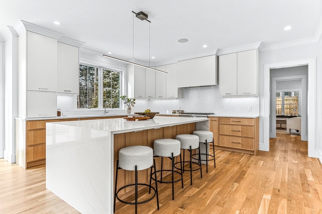 123 Lawton Road Needham, MA 02492 - Photo 5 of 16 a kitchen with stainless steel appliances granite countertop a stove a sink a refrigerator and white cabinets with wooden floor