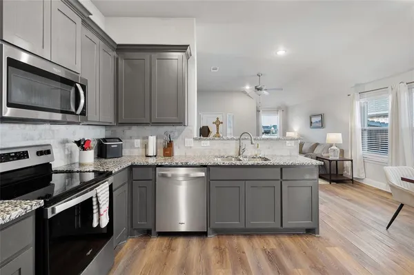 a kitchen with granite countertop cabinets stainless steel appliances and wooden floor