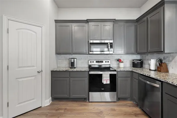 a kitchen with stainless steel appliances granite countertop a stove a sink and a microwave