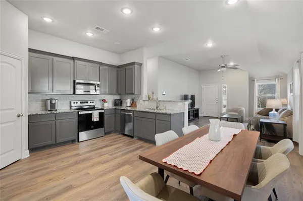 a kitchen with a table chairs sink microwave and cabinets
