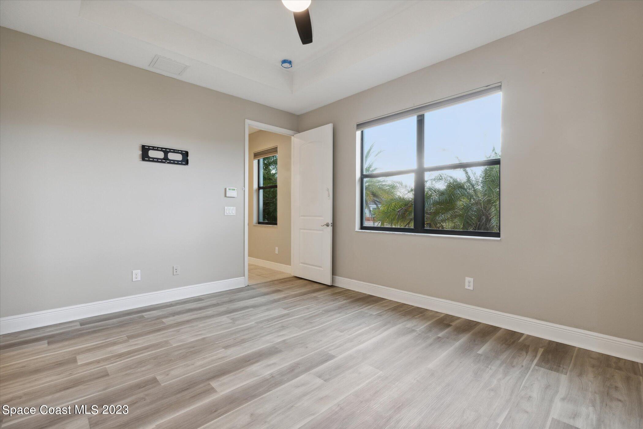 3611 Stabane Place Melbourne, FL 32940 - Photo 17 of 50 an empty room with wooden floor and windows