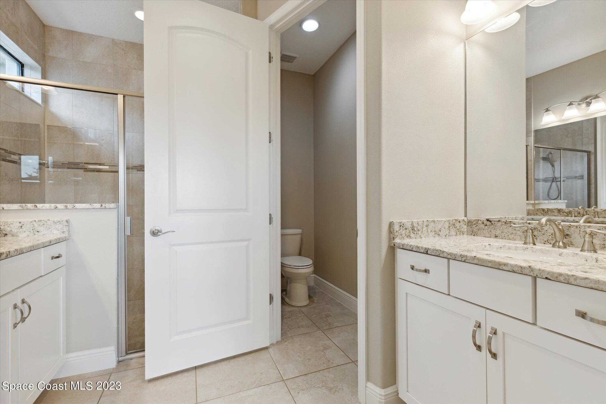 3611 Stabane Place Melbourne, FL 32940 - Photo 19 of 50 a bathroom with a granite countertop sink toilet and shower