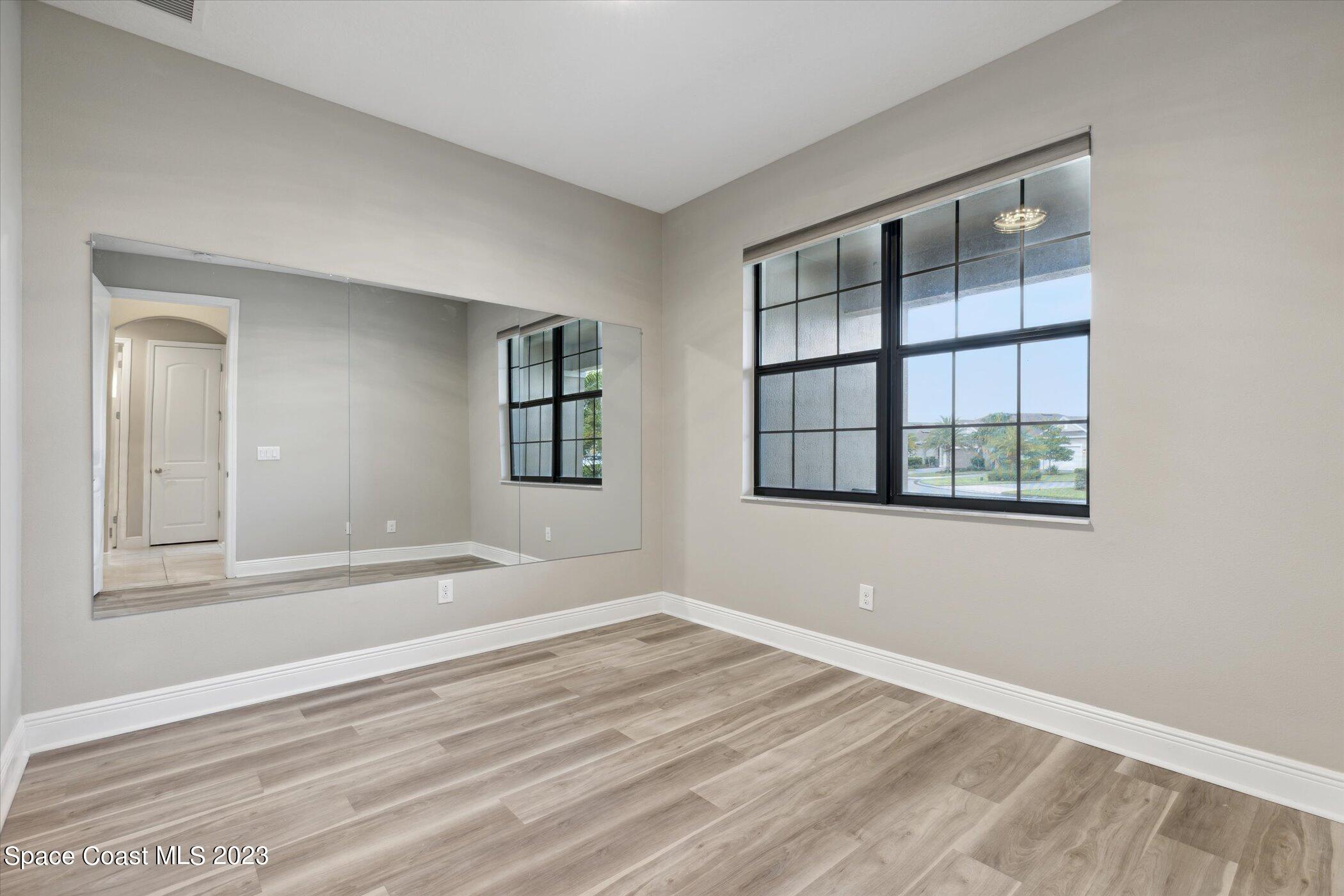 3611 Stabane Place Melbourne, FL 32940 - Photo 23 of 50 an empty room with wooden floor and windows
