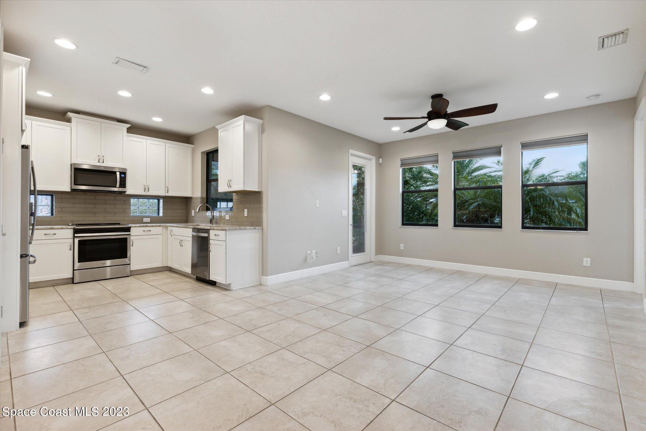 3611 Stabane Place Melbourne, FL 32940 - Photo 8 of 50 a view of kitchen with stainless steel appliances kitchen island granite countertop a refrigerator and a stove top oven