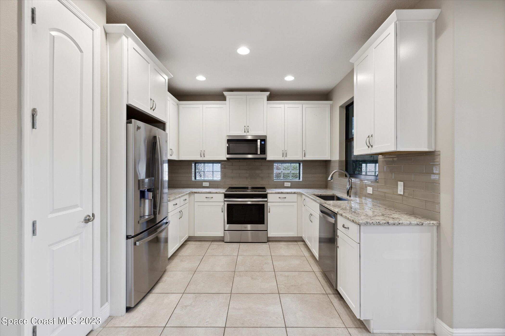 3611 Stabane Place Melbourne, FL 32940 - Photo 10 of 50 a kitchen with stainless steel appliances granite countertop a refrigerator and a stove top oven