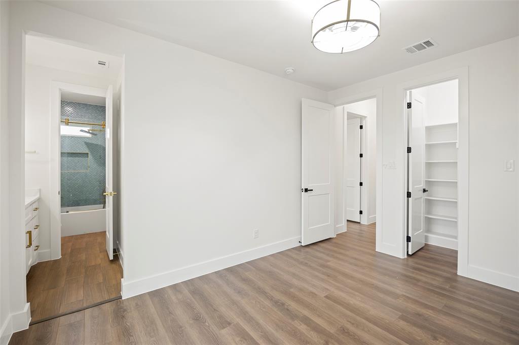 1000 Canyon Lake Road Wills Point, TX 75169 - Photo 20 of 40 Unfurnished bedroom with baseboards, visible vents, a walk in closet, and wood finished floors