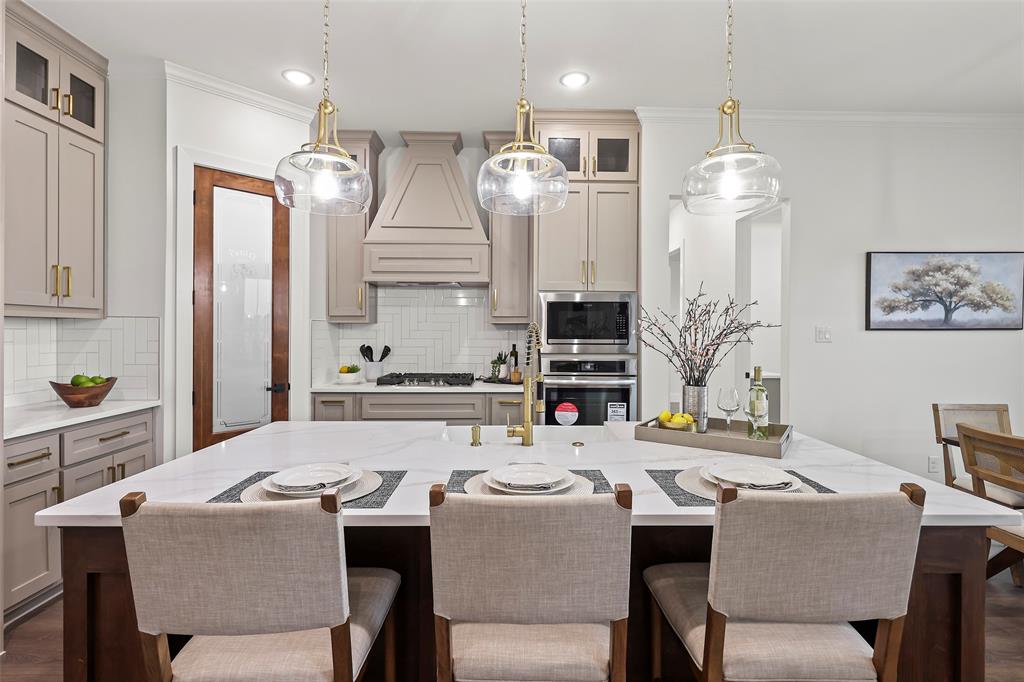 1000 Canyon Lake Road Wills Point, TX 75169 - Photo 24 of 40 Kitchen featuring crown molding, pendant lighting, premium range hood, glass insert cabinets, and built in microwave