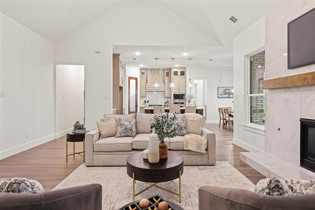 1000 Canyon Lake Road Wills Point, TX 75169 - Photo 27 of 40 Living room with visible vents, high vaulted ceiling, wood finished floors, and a tile fireplace