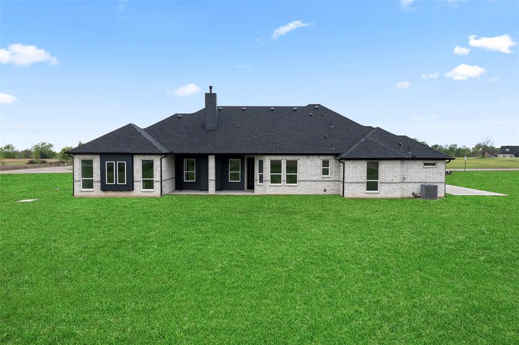 1000 Canyon Lake Road Wills Point, TX 75169 - Photo 28 of 40 Rear view of house featuring a lawn, a chimney, central AC, and roof with shingles