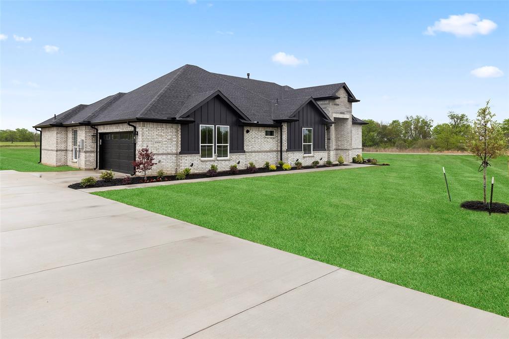 1000 Canyon Lake Road Wills Point, TX 75169 - Photo 39 of 40 View of front of property featuring driveway, a front yard, brick siding, board and batten siding, and a garage