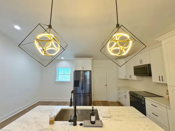 a kitchen with kitchen island granite countertop a stove and a sink