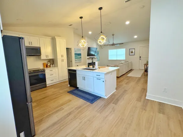 a large kitchen with stainless steel appliances a large counter top