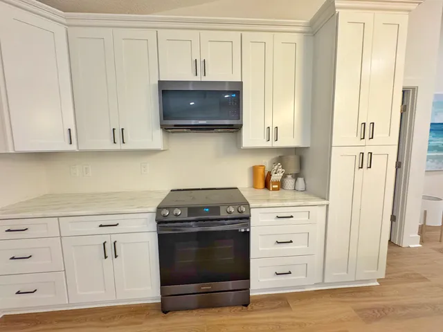 a kitchen with white cabinets and a stove