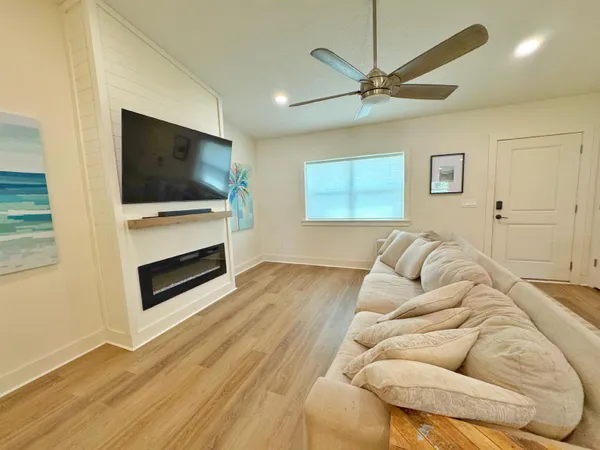 a living room with furniture a flat screen tv and a fireplace