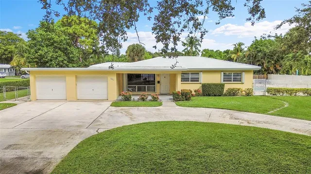 a front view of a house with a yard and trees